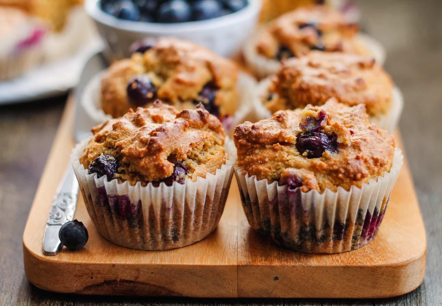 freshly baked almond flour blueberry muffins on a board.
