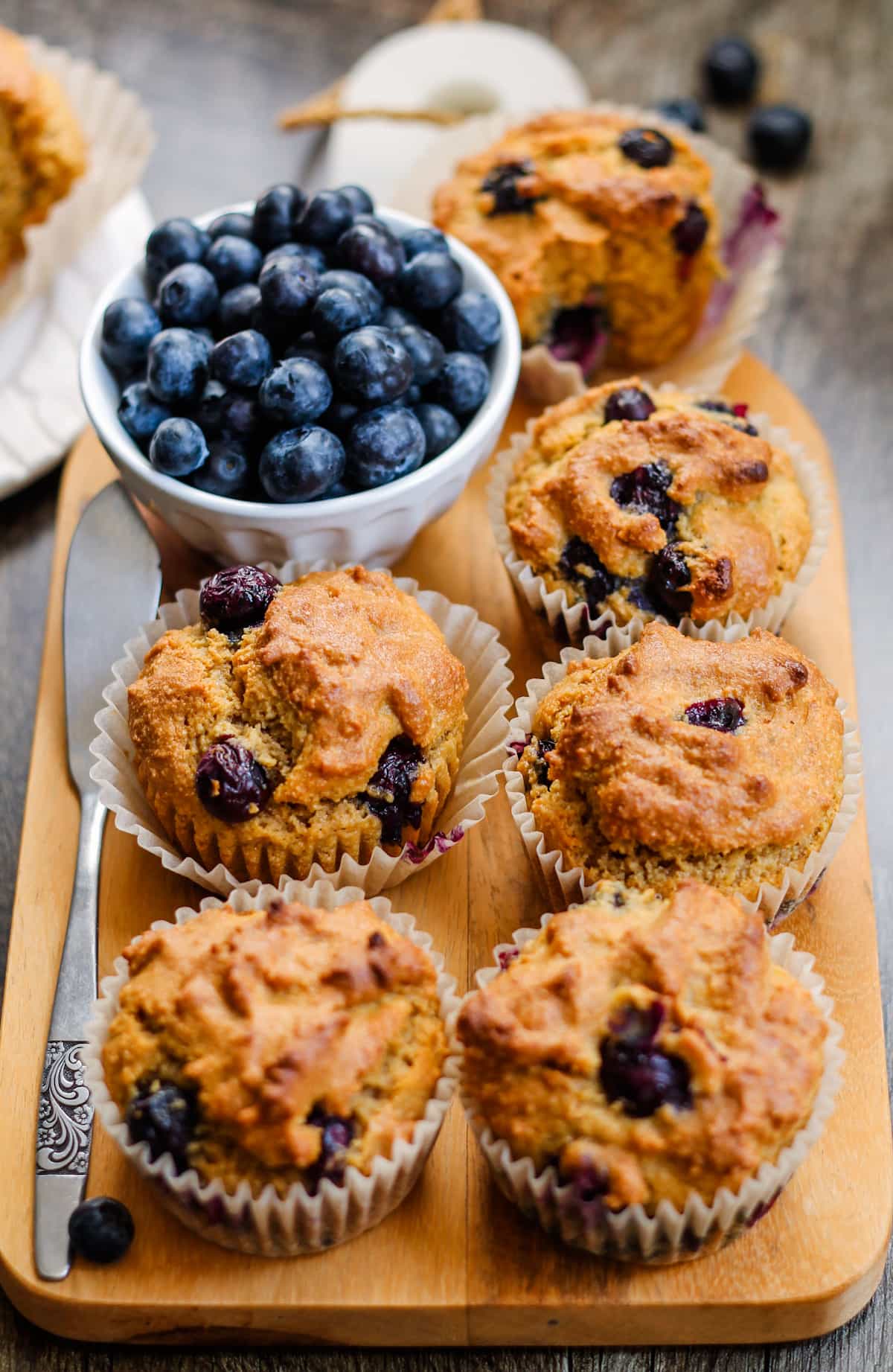 a board topped with almond flour blueberry muffins.