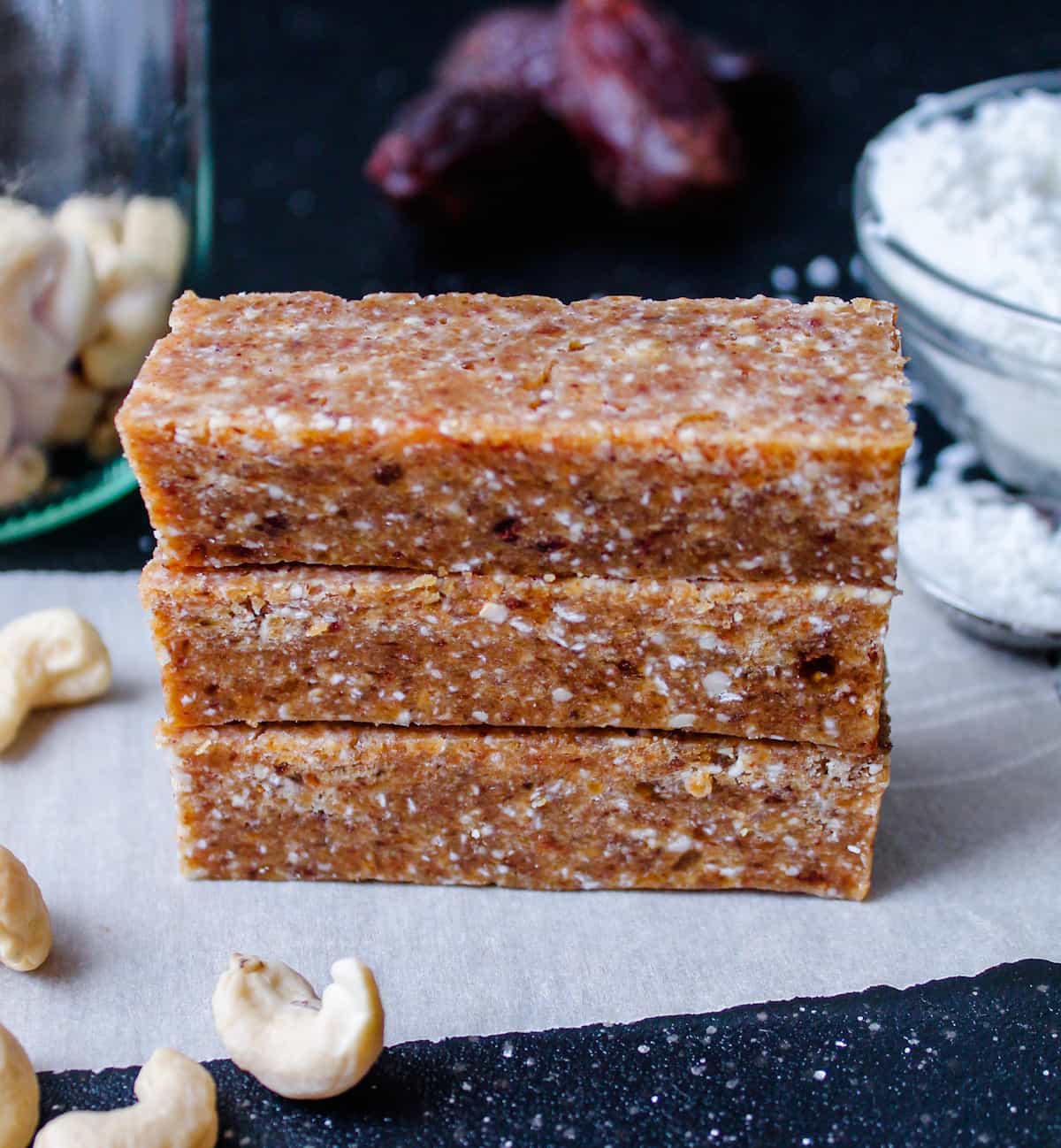 a stack of no bake coconut cashew date bars.
