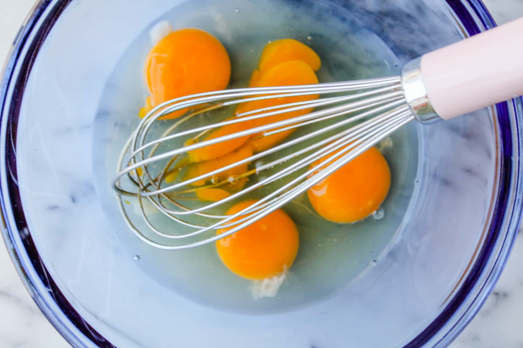 eggs being whisked in a bowl.