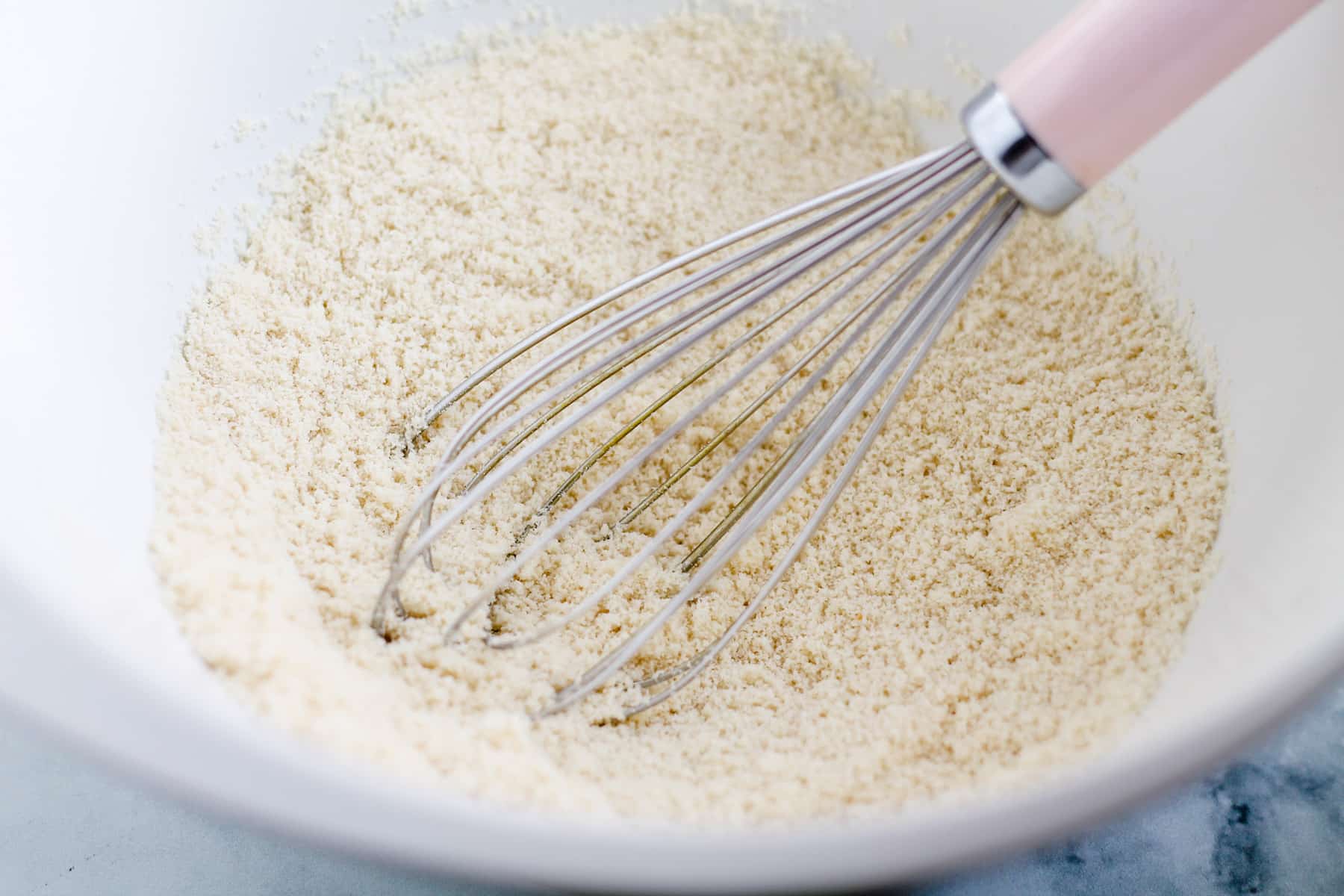 dry ingredients being whisked in a bowl.