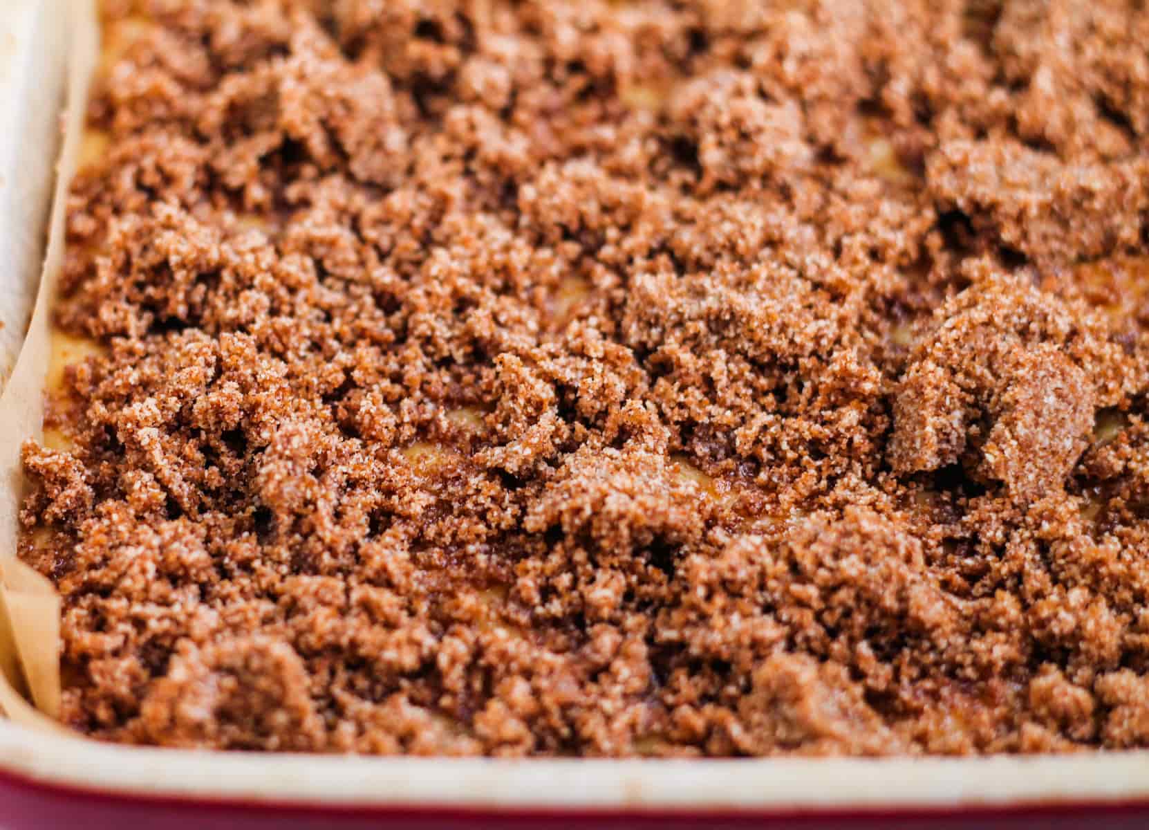 crumble topping on top of cake batter in a baking dish.
