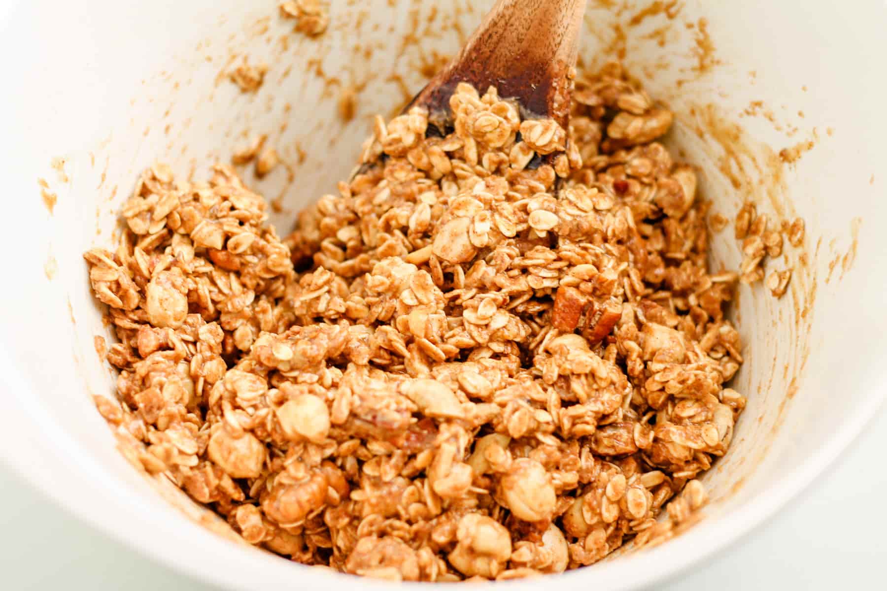 granola mixture being stirred in a bowl.