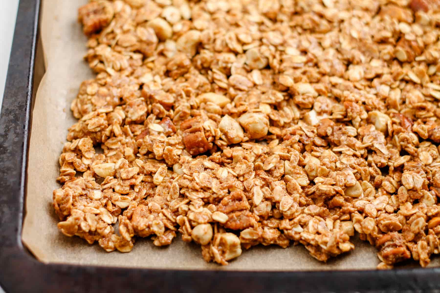 granola mixture spread onto a baking sheet.