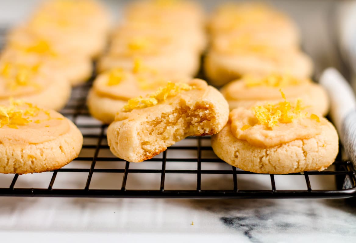 A batch of almond flour lemon cookies cooling on a wire rack.