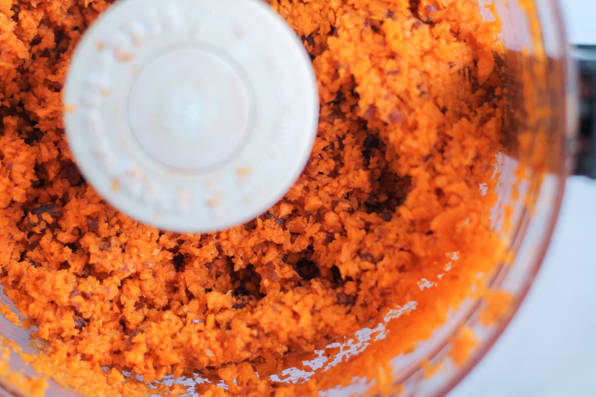 carrots and dates being chopped in a food processor.