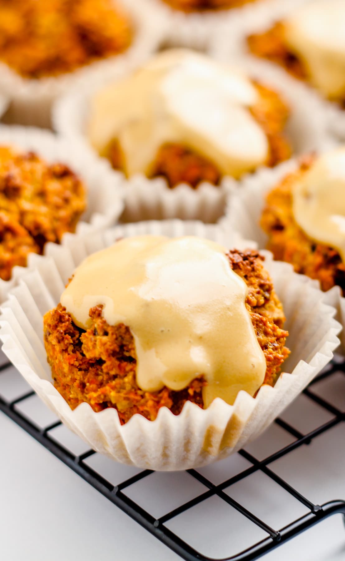 carrot spelt muffins with a glaze on top.