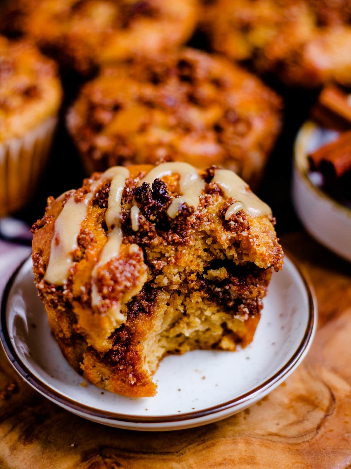 a glazed cinnamon roll muffin on a plate.