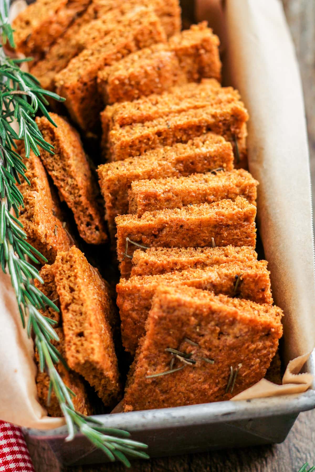 a basket of flaxseed flatbread with a sprig of rosemary as a garnish.
