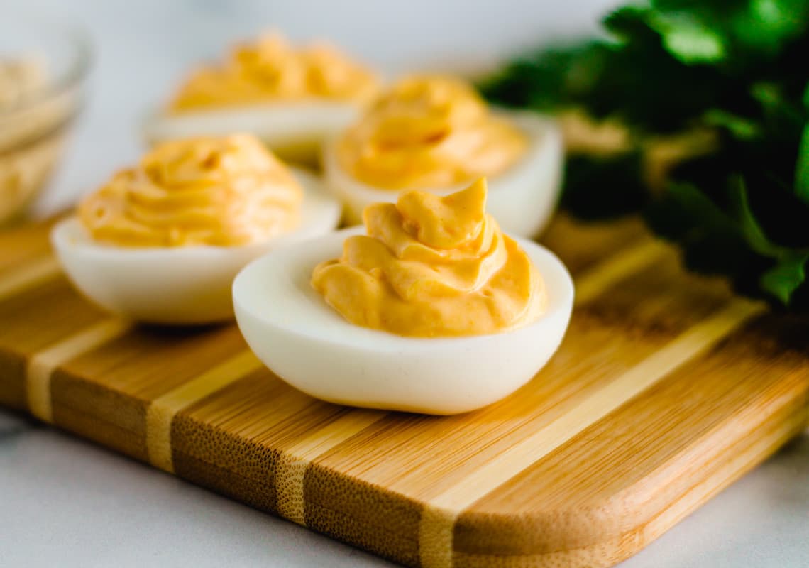 a serving tray with a display of hummus deviled eggs.