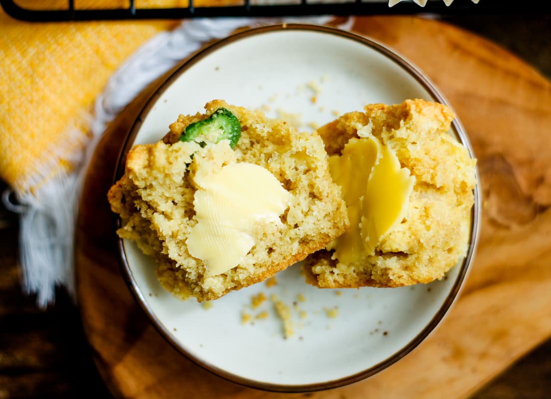 a buttered jalapeno muffins on a small plate.