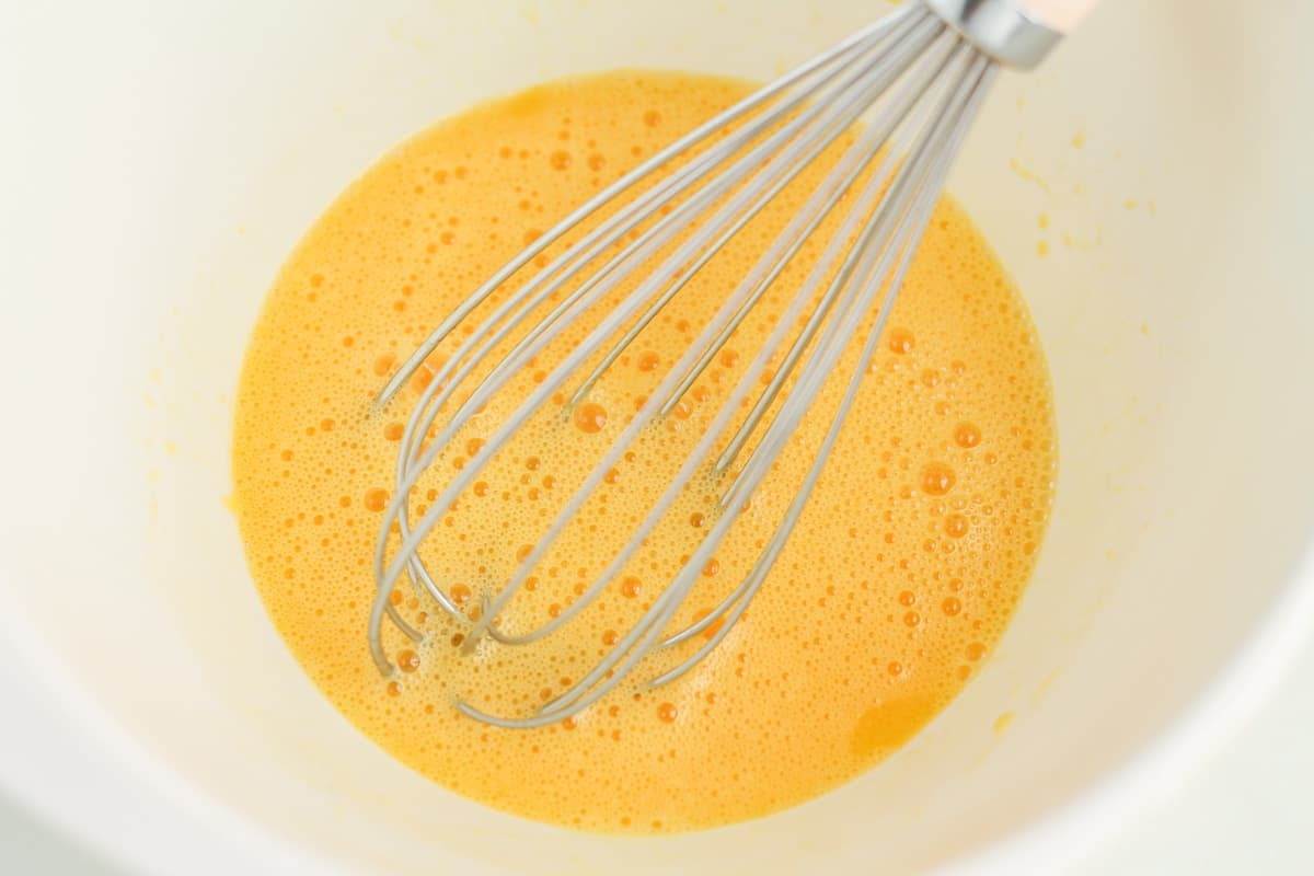 eggs being whisked in a bowl.