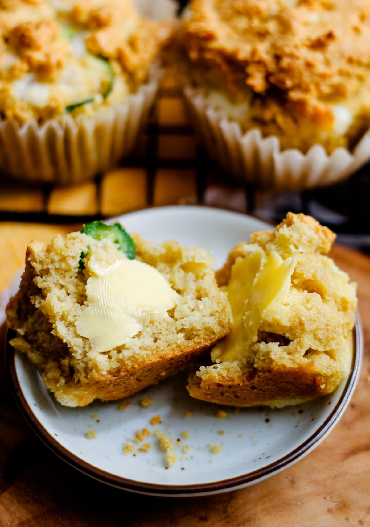 a buttered jalapeno muffin on a plate.