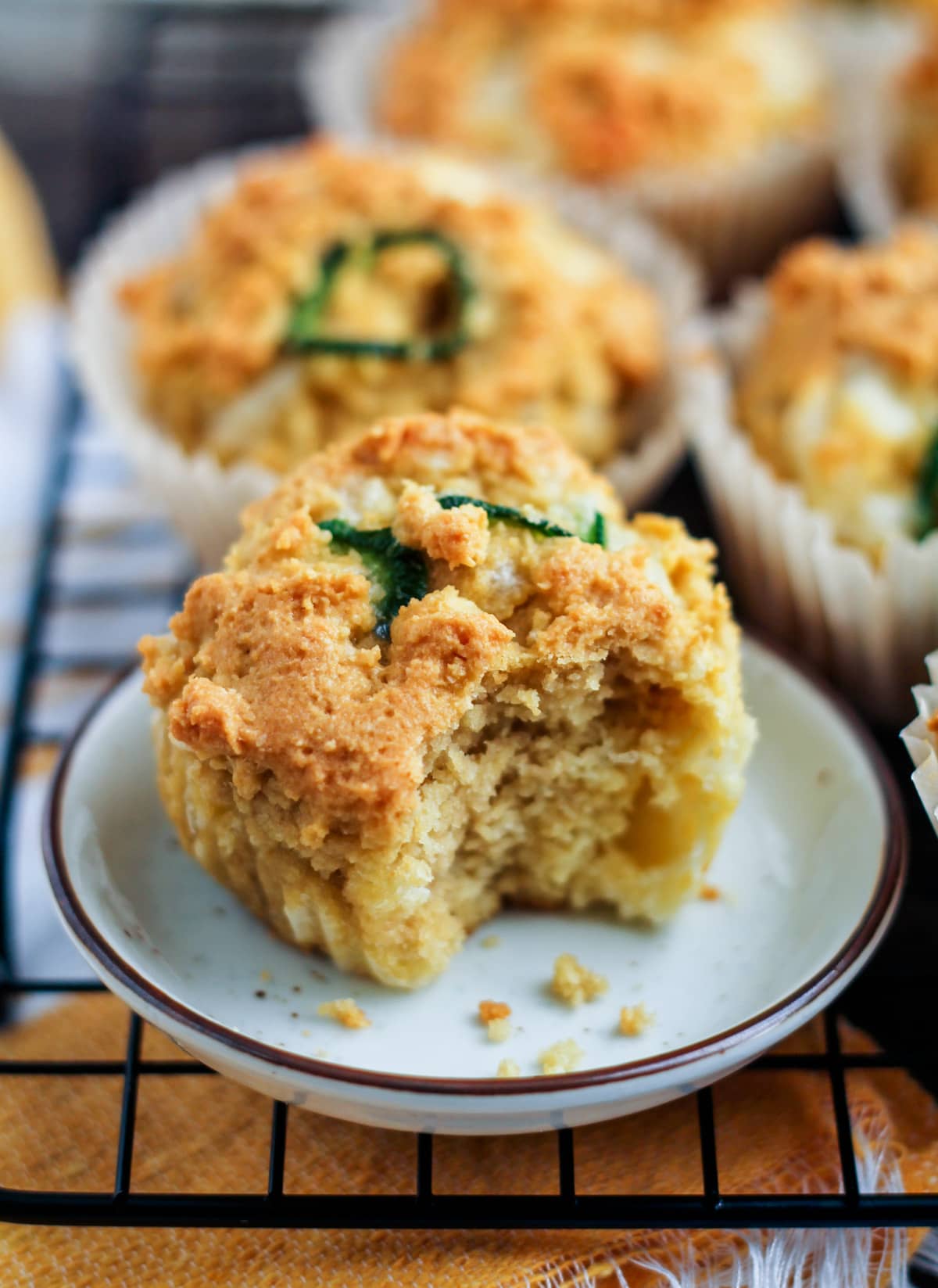 a jalapeno muffin with a bite out of it on a wire rack.