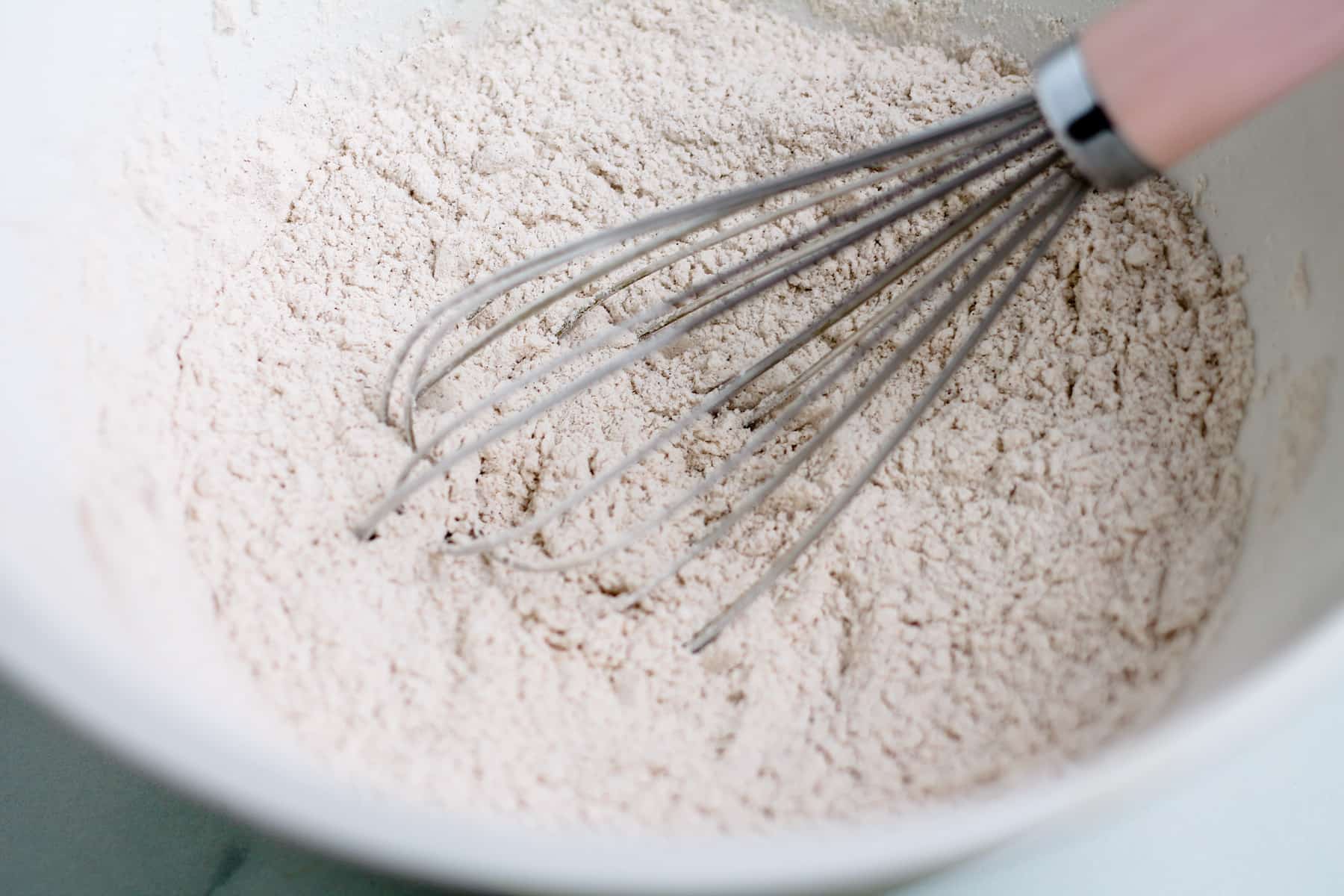 a bowl with dry ingredients being whisked.