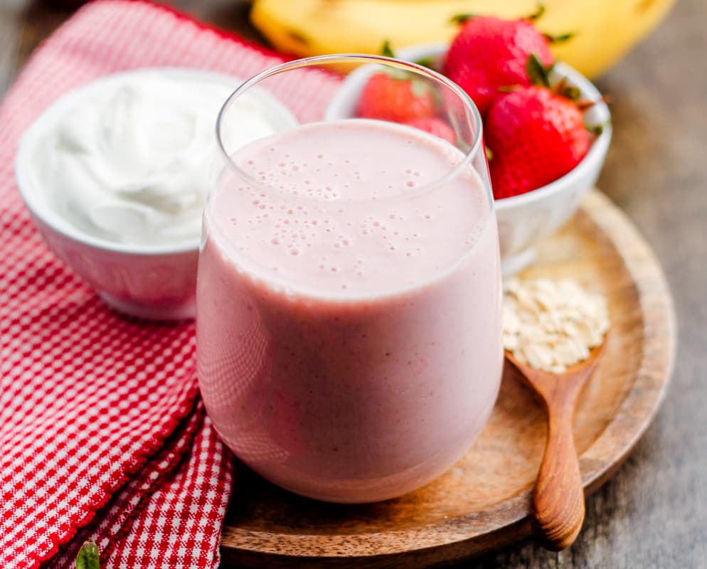 a tray with a glass of strawberry banana oatmeal smoothie.