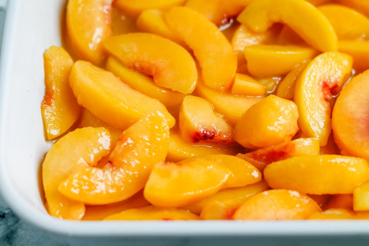 a baking dish with peaches inside.
