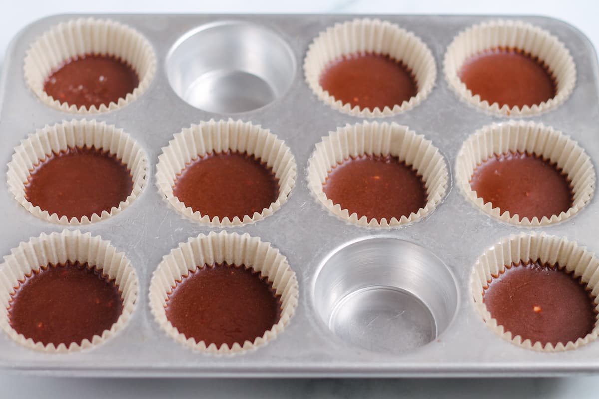 A muffin tin with chocolate cups out of the freezer.