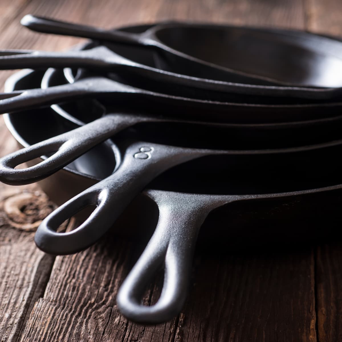 A stack of cast iron pans on a table.