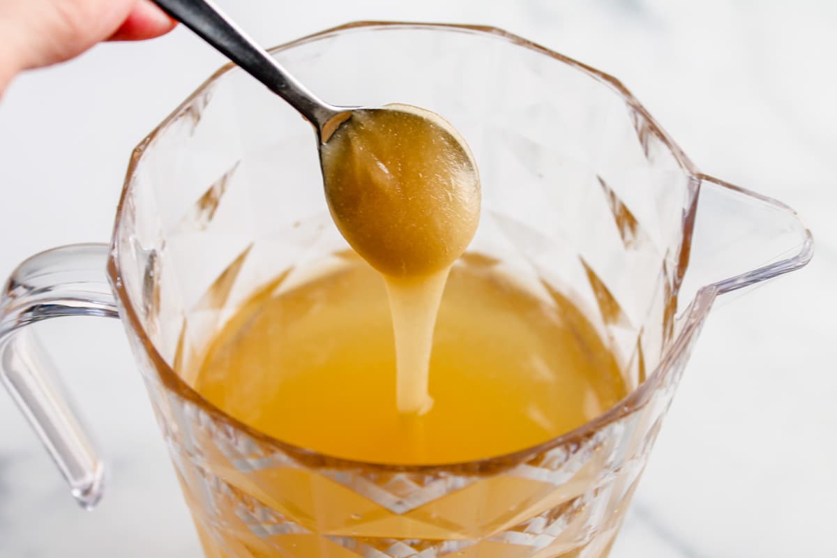 Honey being poured into a pitcher.