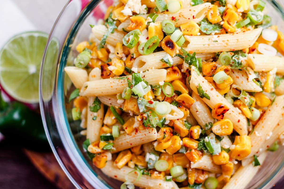 A glass bowl with Mexican Street Corn Pasta Salad inside.