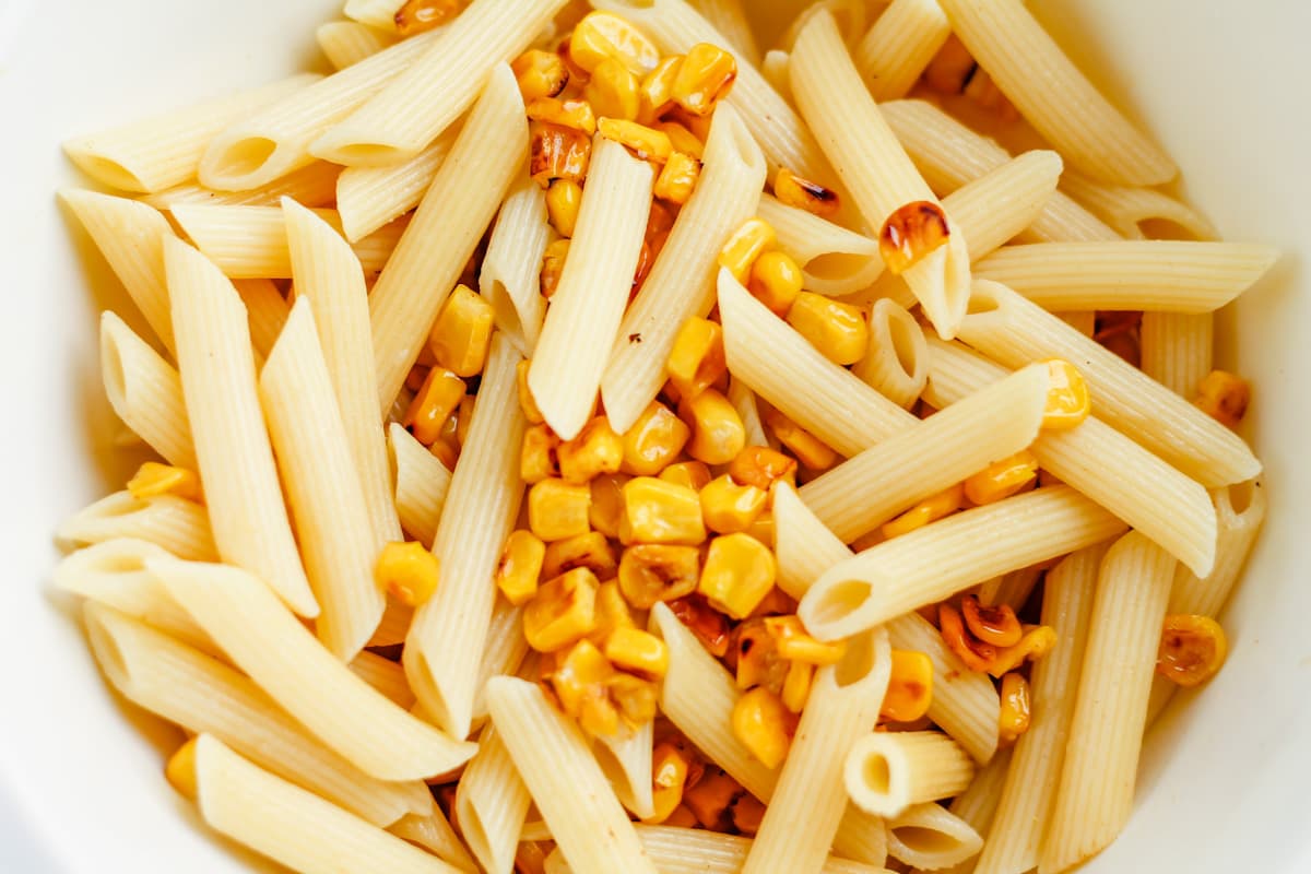 Corn and pasta in a mxing bowl.