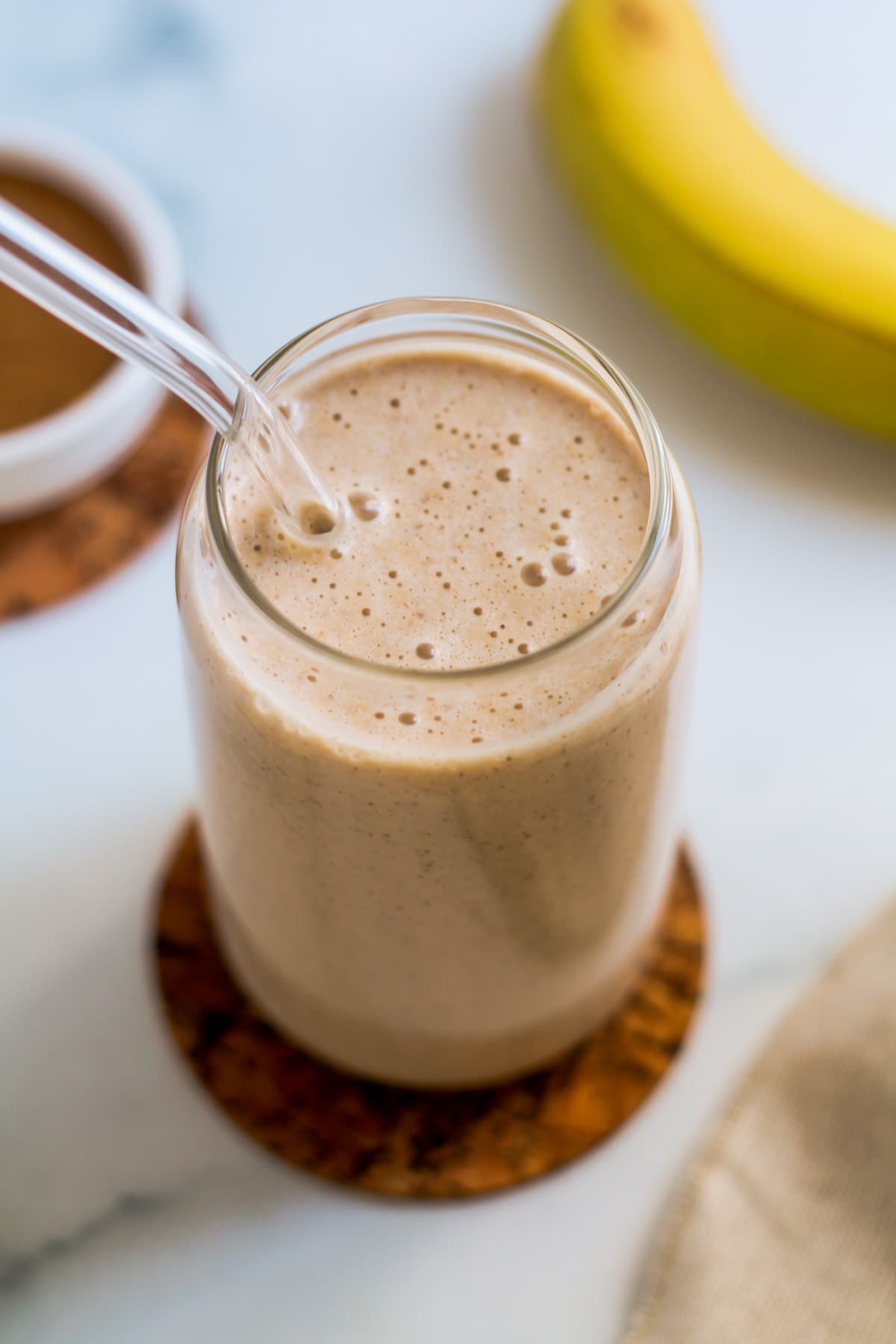 A glass filled with Banana Almond Butter Smoothie.