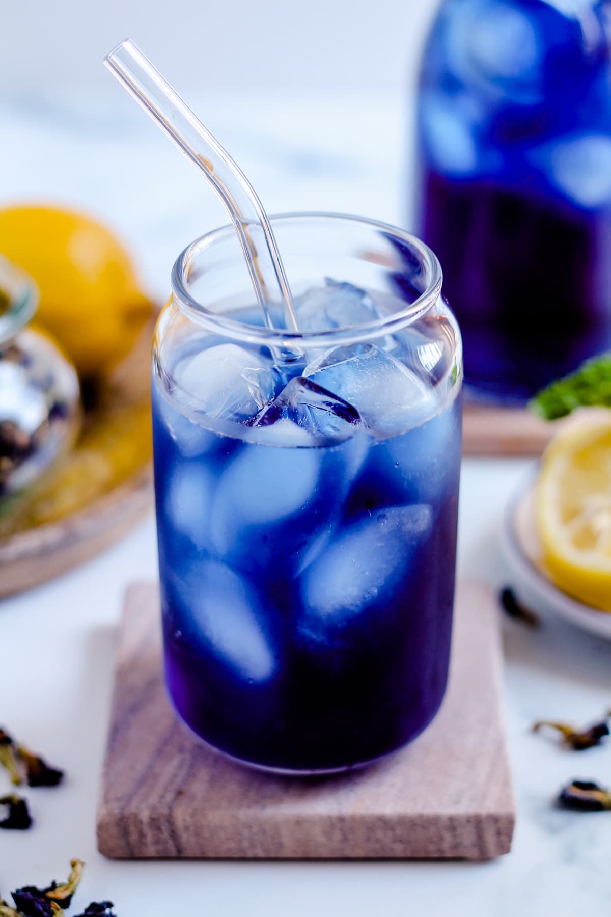 A glass with a brilliant blue drink in it over ice.