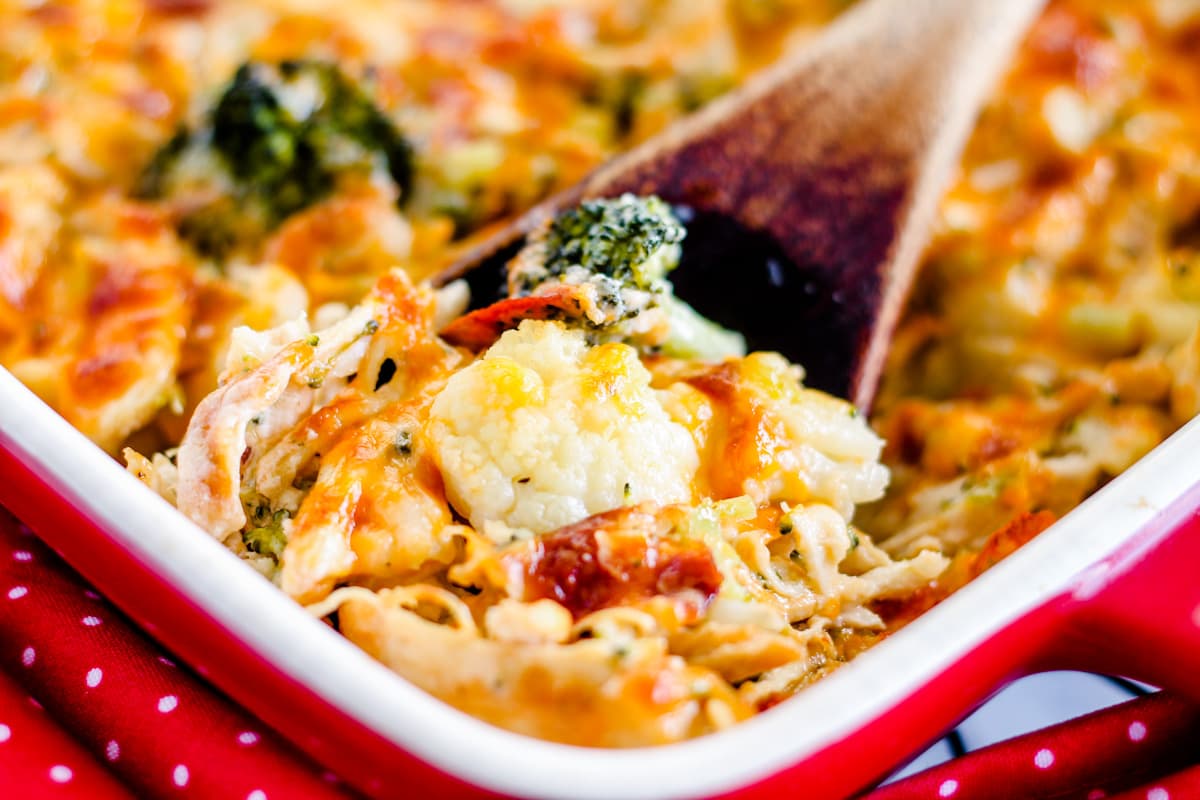 A spoon scooping out cauliflower chicken casserole.