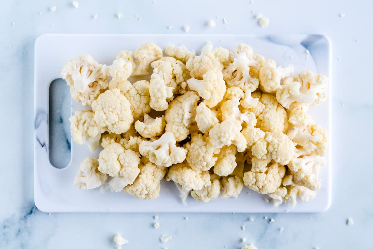 Cauli florets on a cutting board.