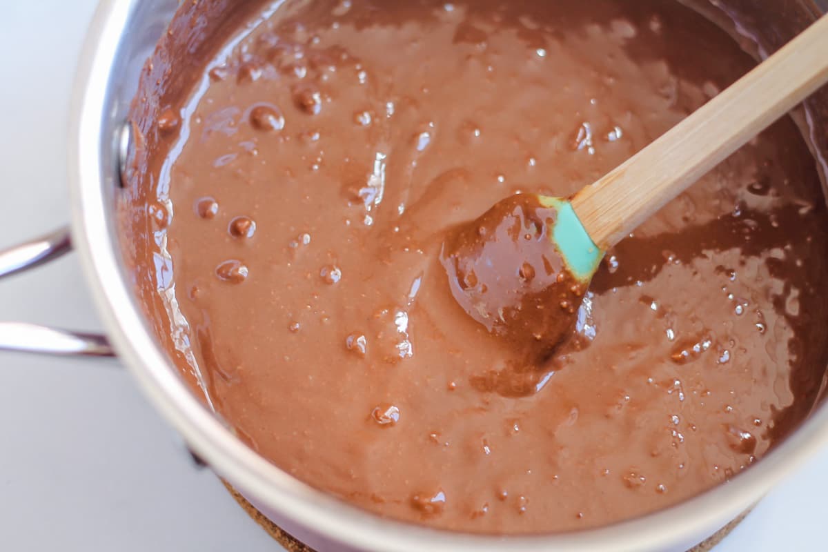 Peanut butter and chocolate being melted together in a saucepan.
