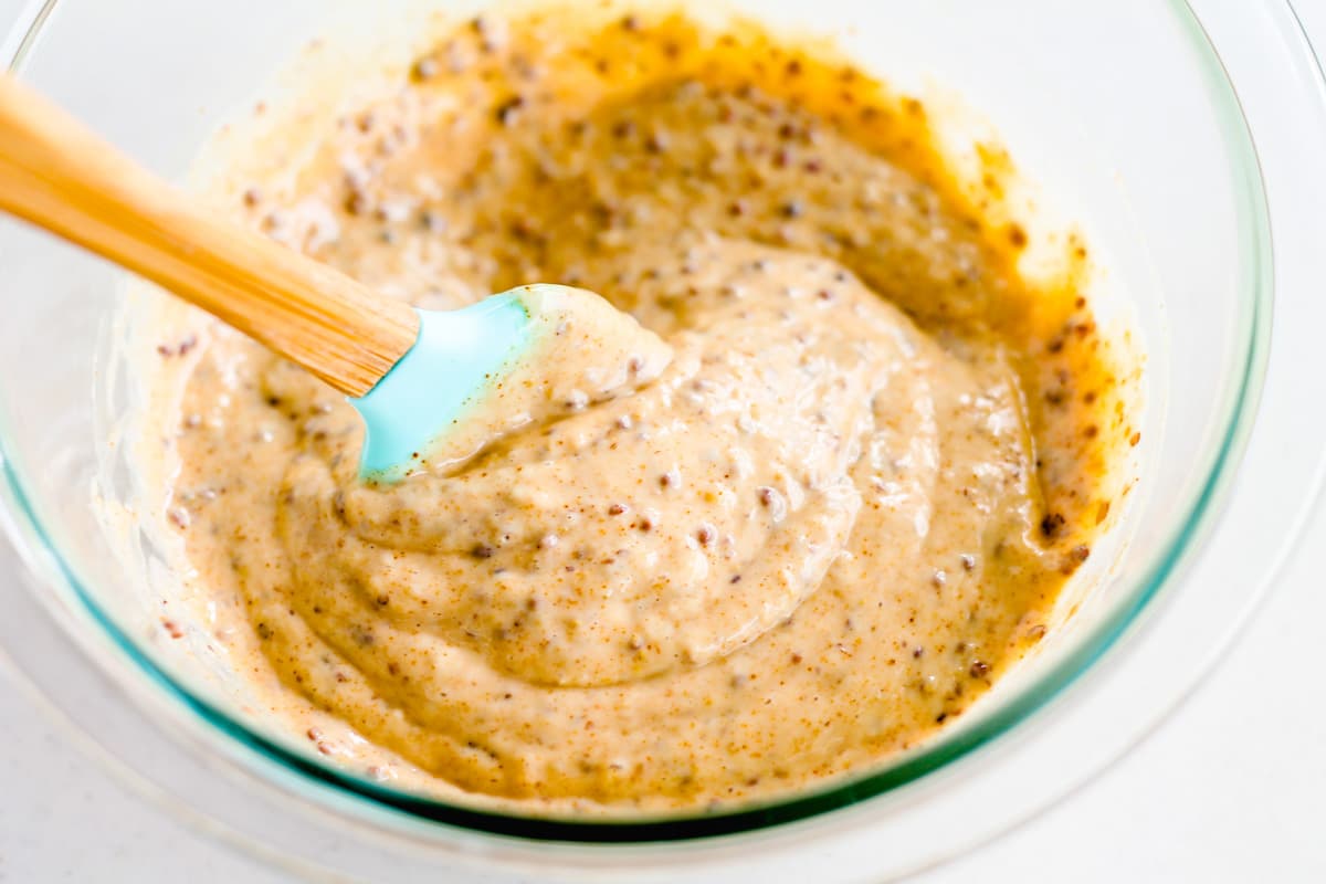 A spatula stirring ingredients in a mixing bowl.