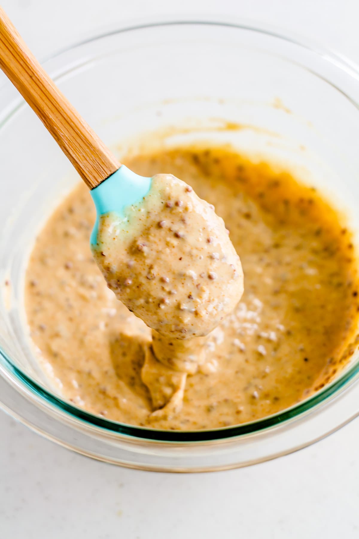 Creamy mixture dripping off a spatula.