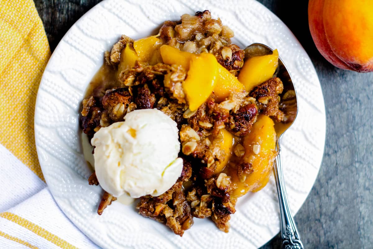 Overhead image of peach crisp with vanilla ice cream.