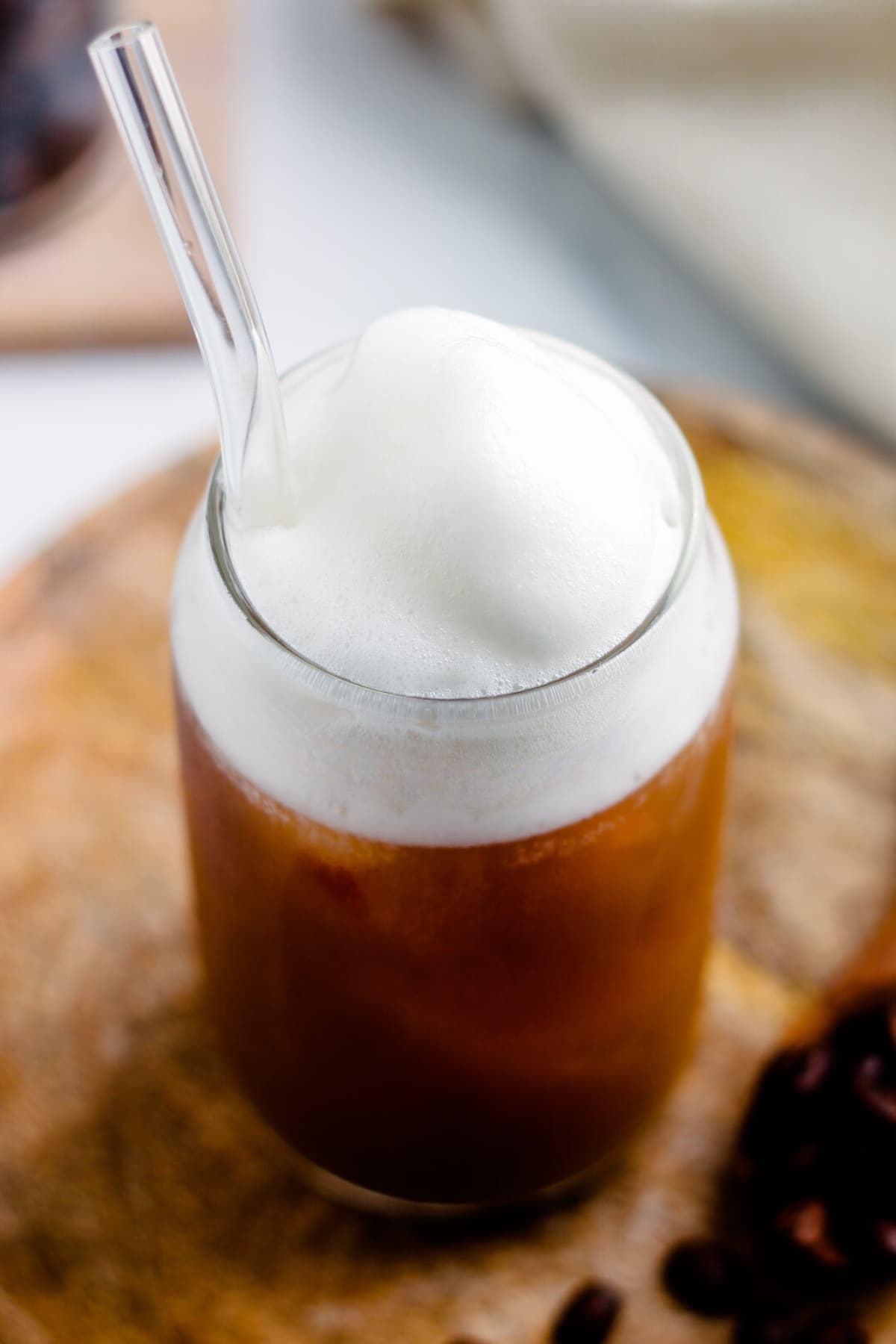 A glass of iced coffee topped with vanilla cold foam.