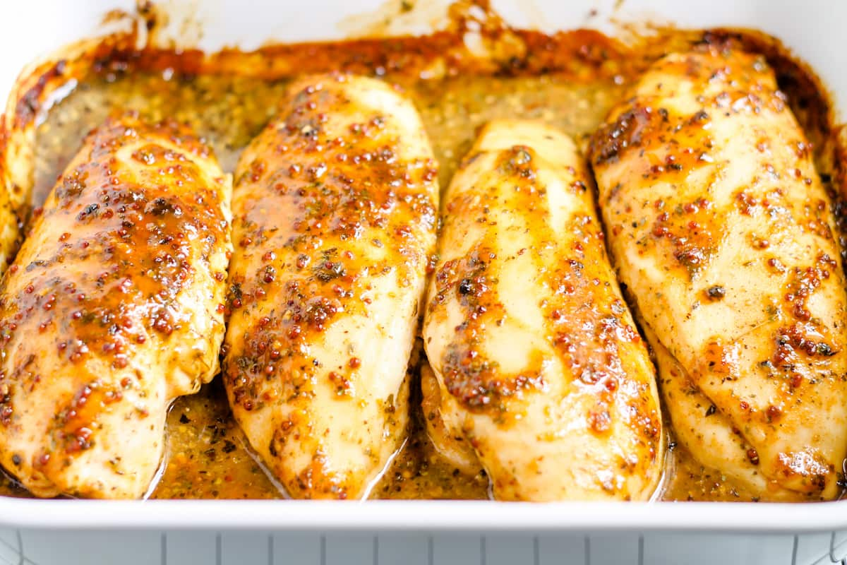 Baked honey mustard chicken breasts in a casserole dish.