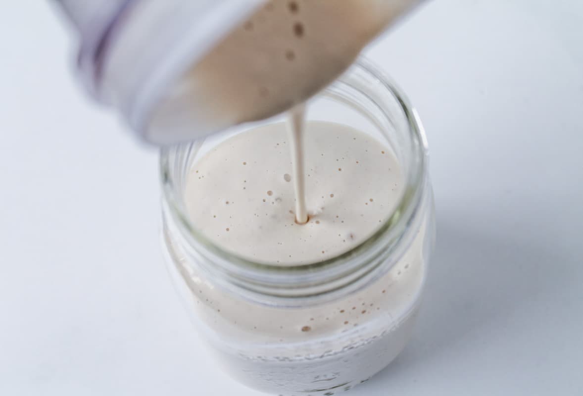 Cashew Cream being poured into a jar.