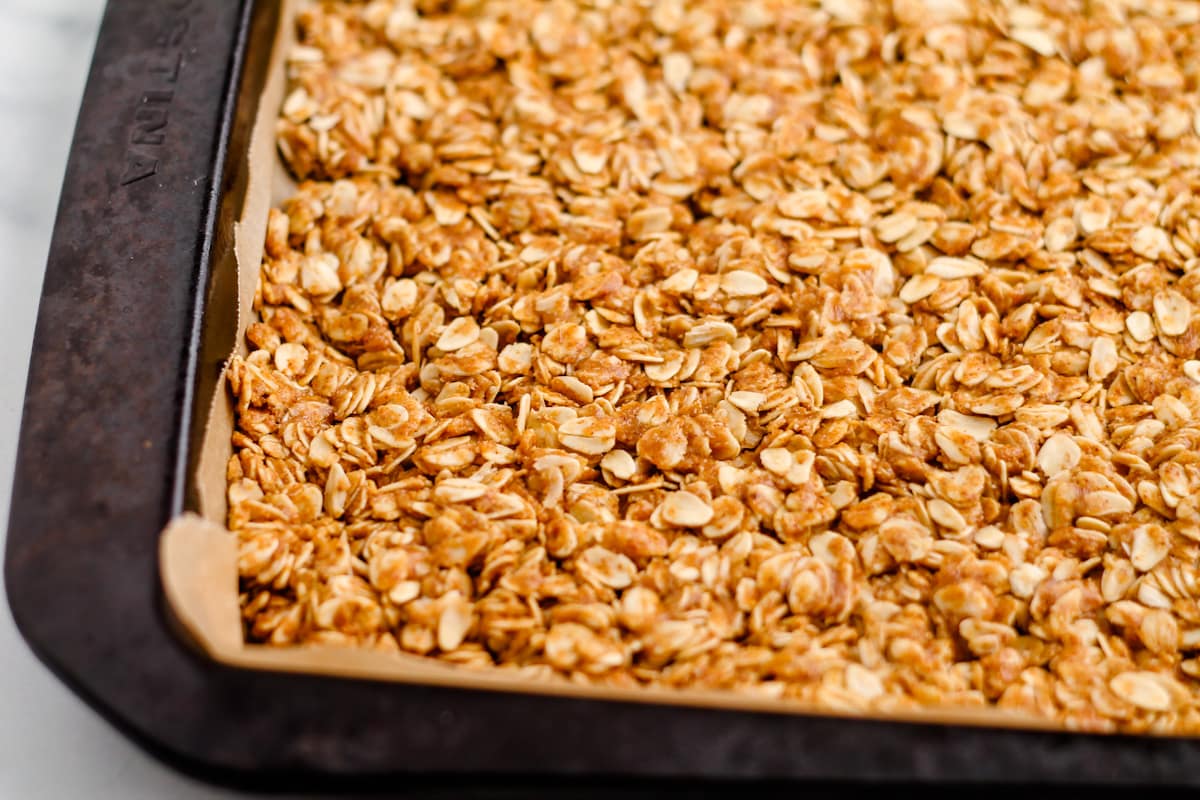 Oat mixture pressed into a parchment lined baking sheet.
