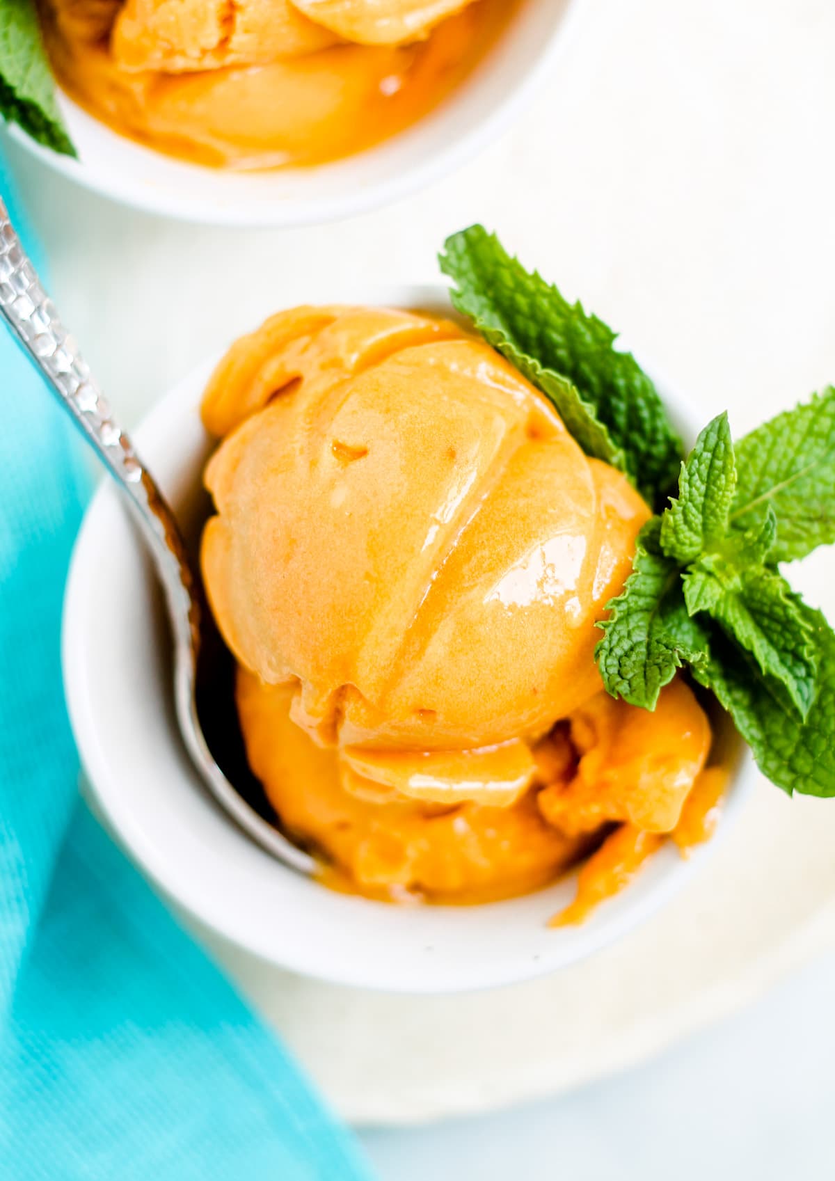A bowl of Peach Sorbet garnished with fresh mint.