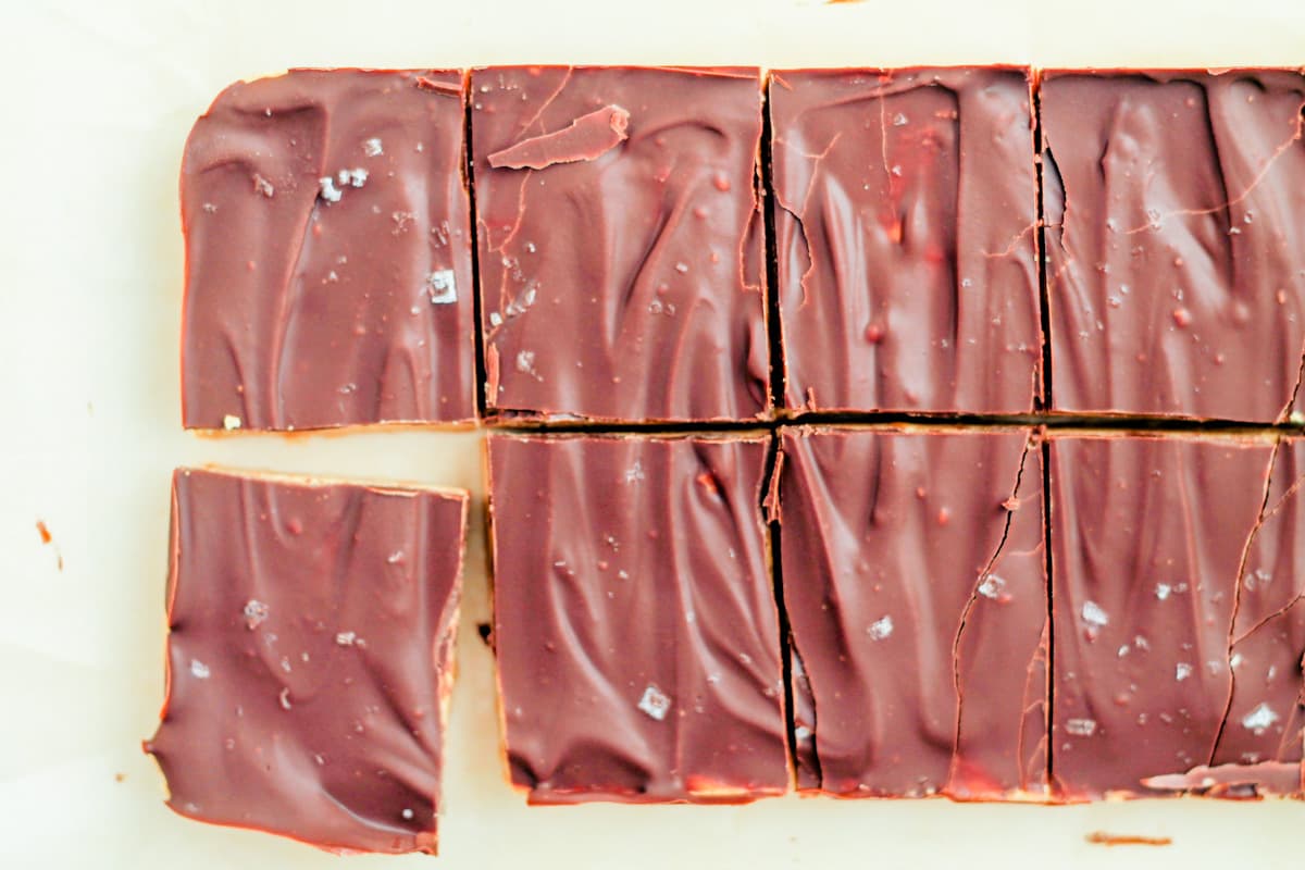 Protein fudge bars cut into squares on a piece of parchment paper.