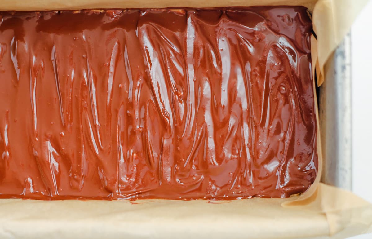 Chocolate spread on top of a mixture in a loaf pan.