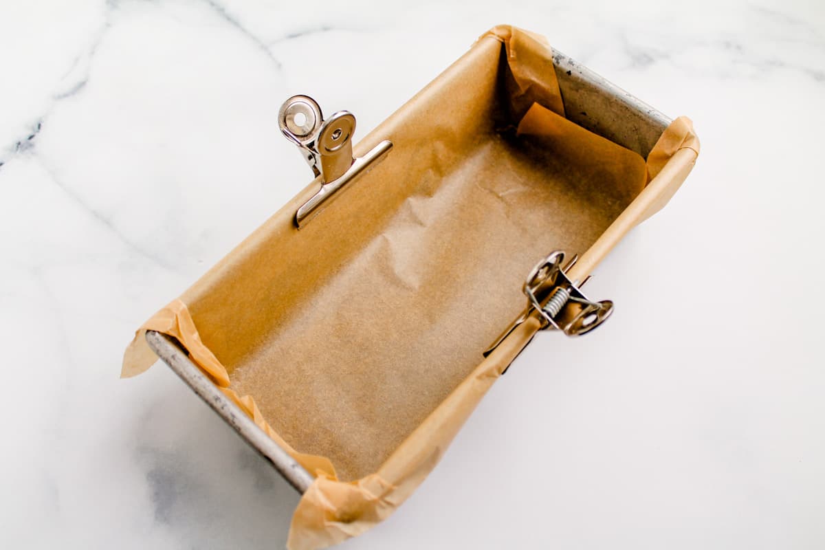 A loaf pan lined with parchment paper.