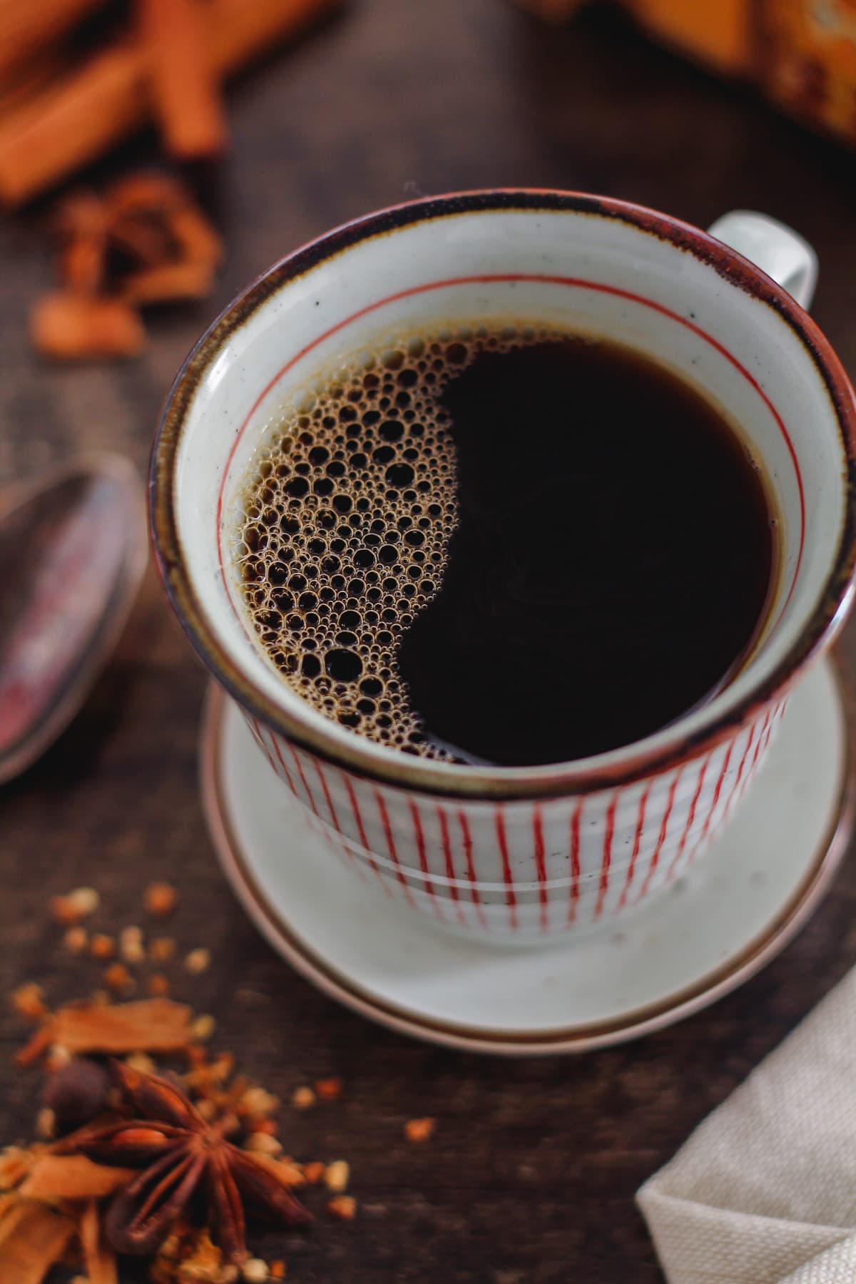 A cup of spiced chai coffee o a table.