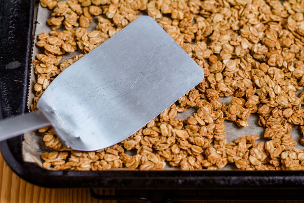 A flat spatula pressing down on warm oat mixture.