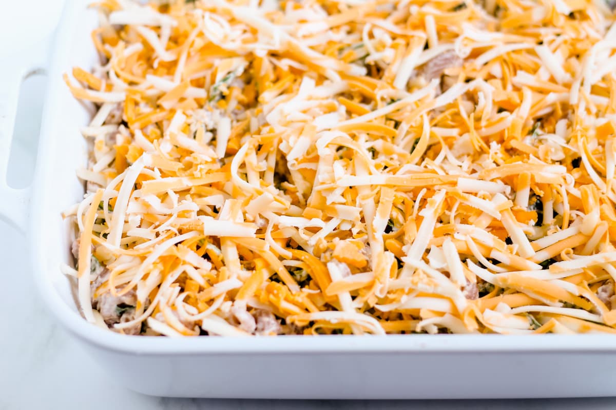 Shredded cheese on top of a mixture in a baking dish.