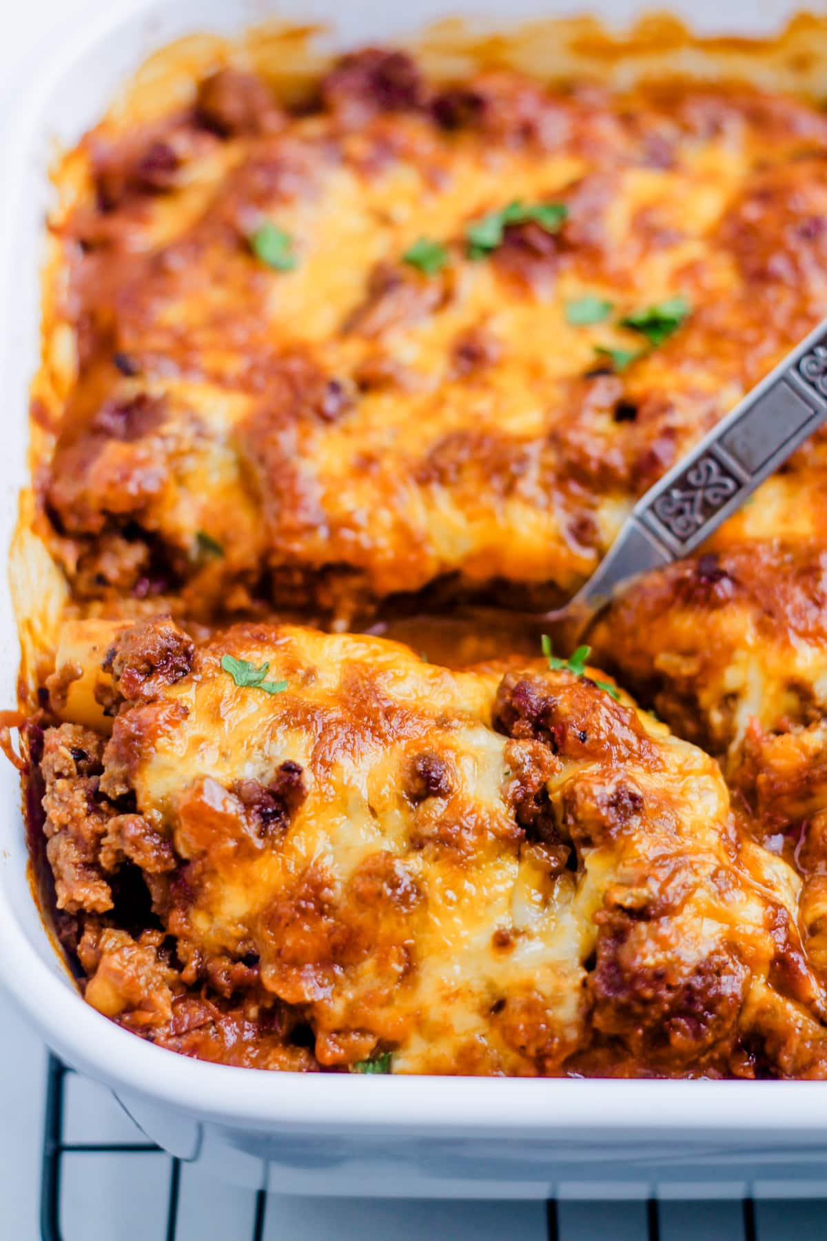 A spoon scooping a portion of taco potato casserole.