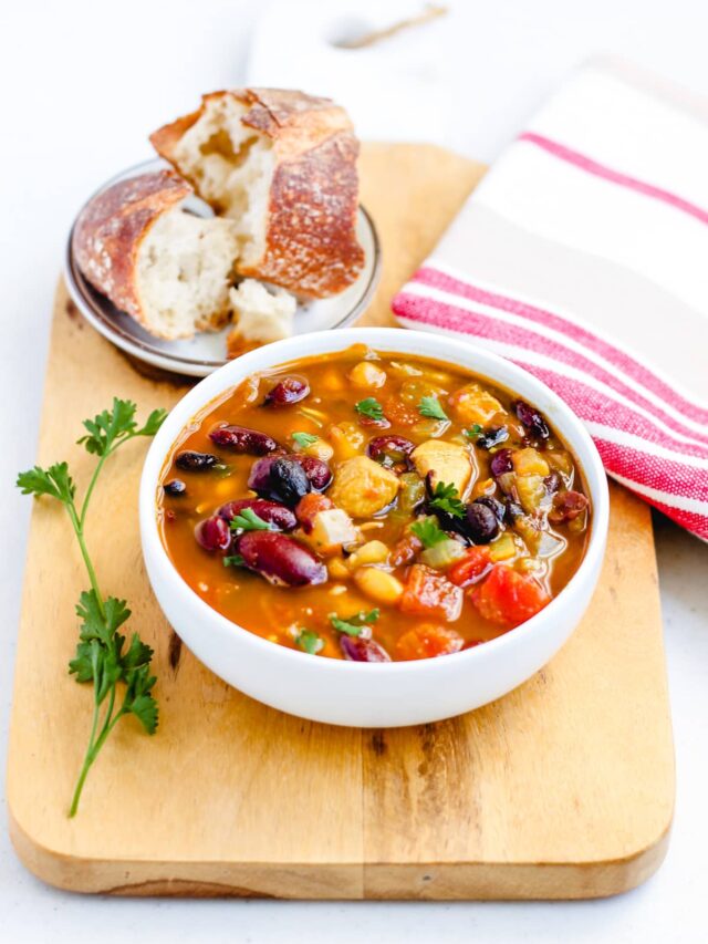 A bowl of three bean chicken soup on a table.