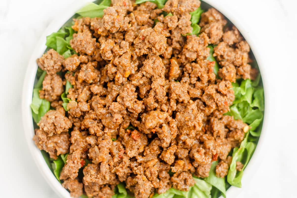 Spiced ground beef on top of a bed of lettuce.
