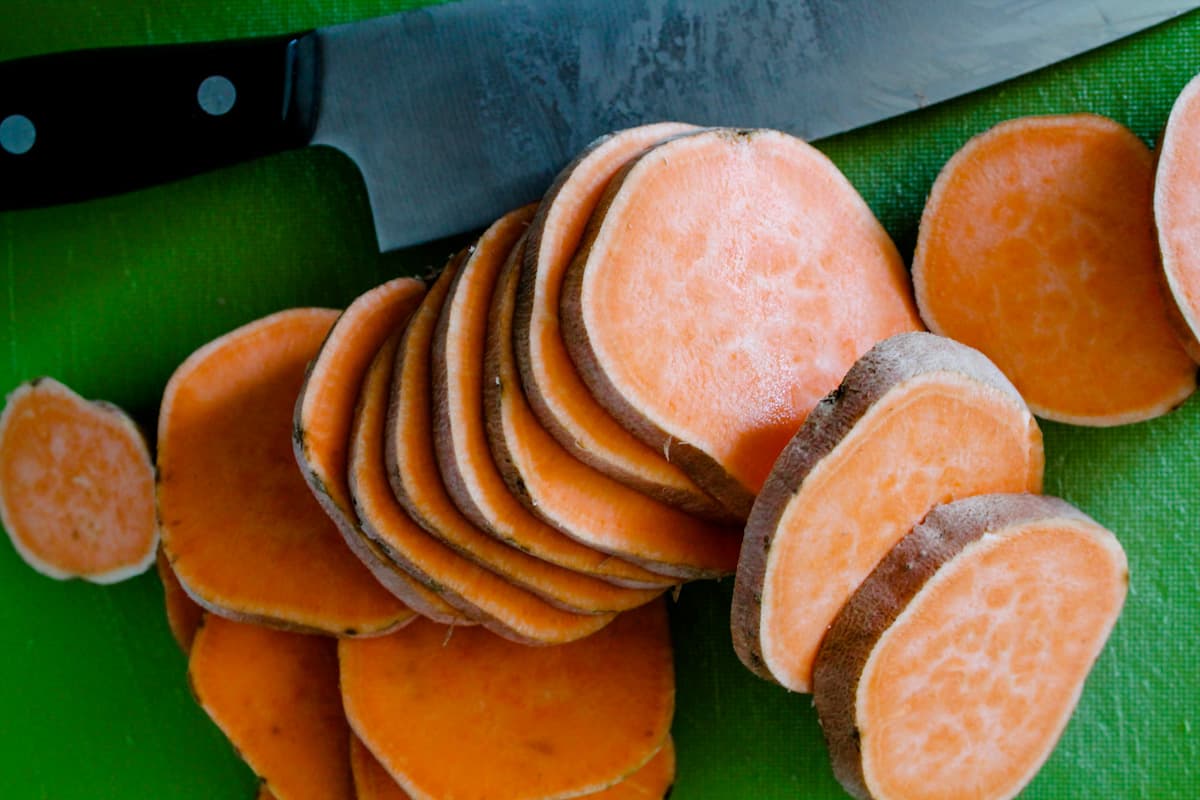 Slices of sweet potatoes on a cutting board.