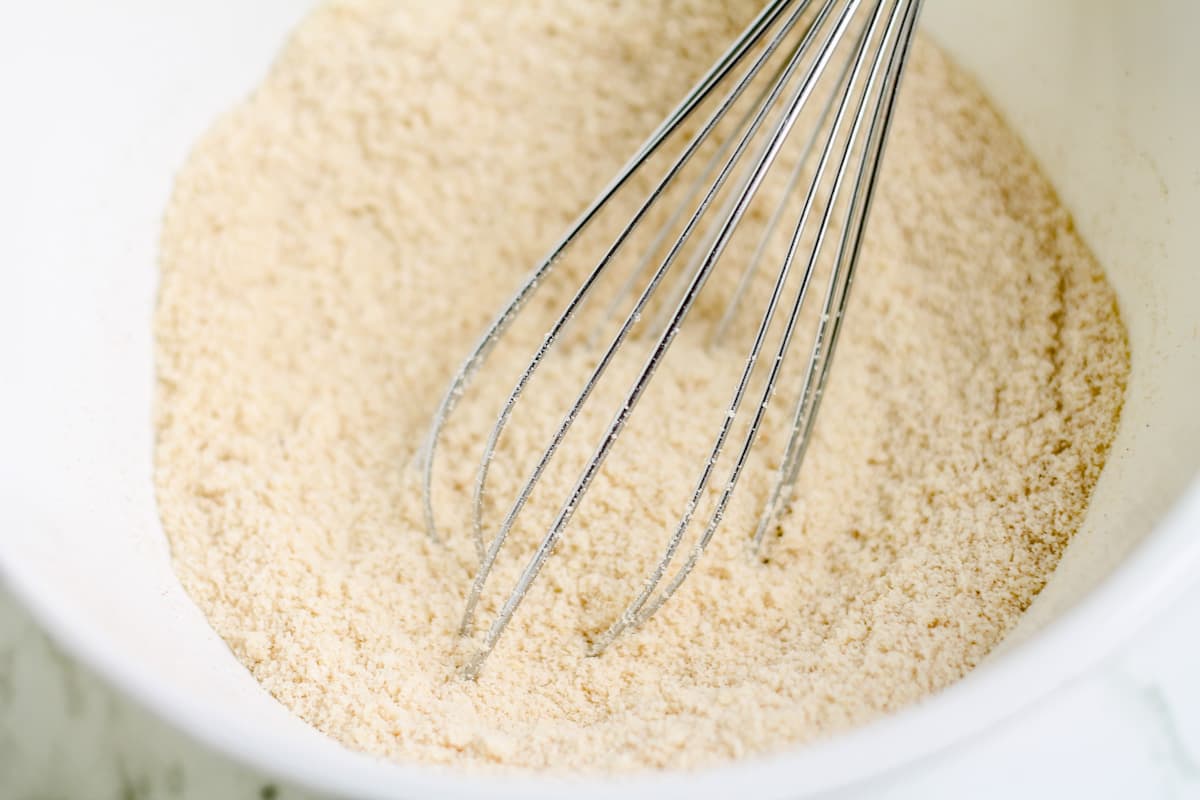 A bowl of dry ingredients being whisked.